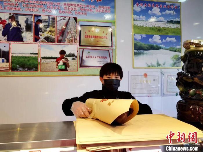 圖為鄭繼梅正在打包烤鵝?！≈x宏秀供圖